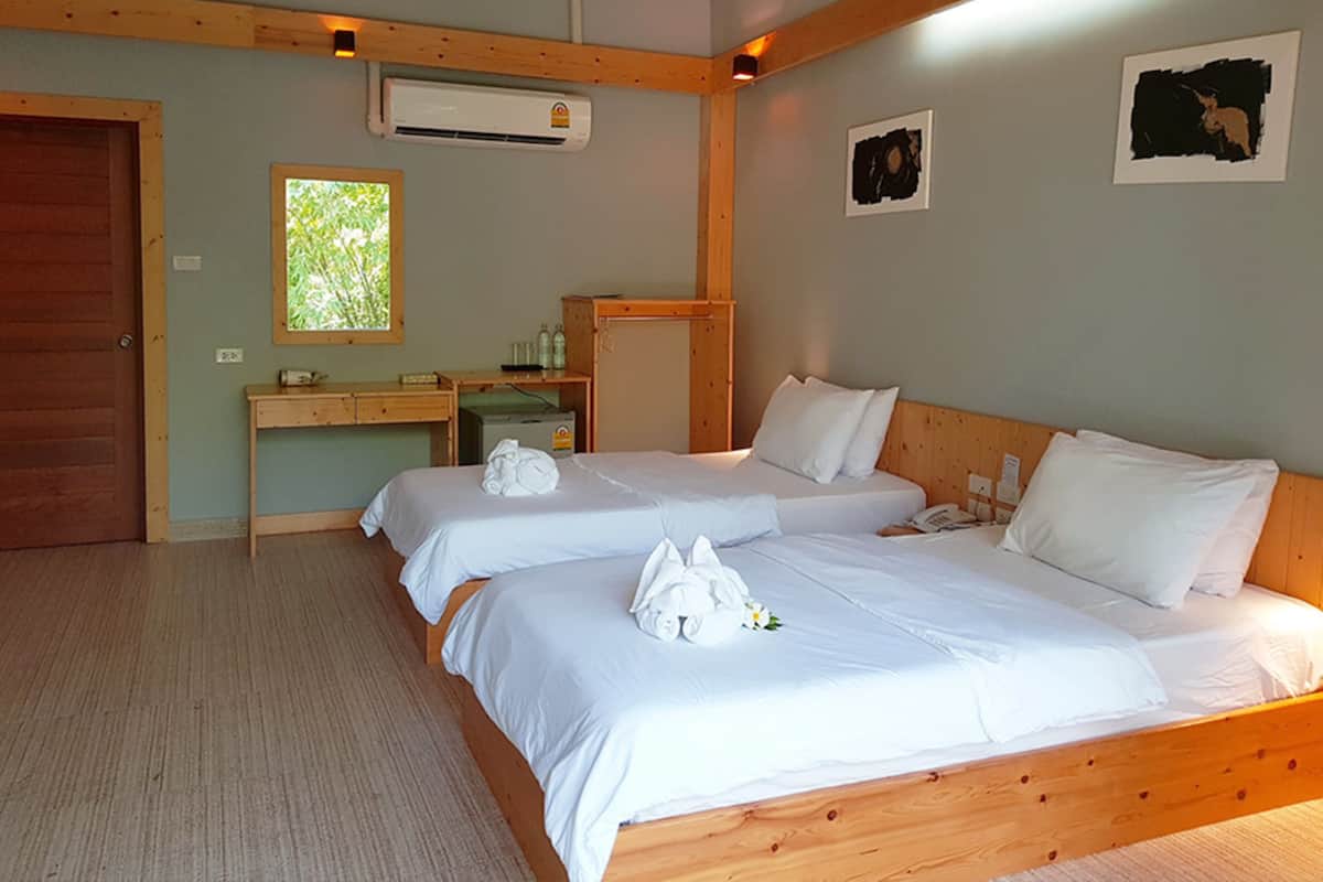 Une chambre d’hôtel avec deux lits, un bureau et une fenêtre.
