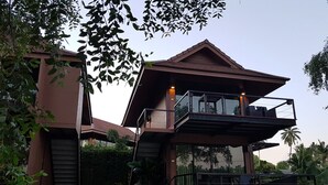 Una casa moderna con balcón y una escalera que conduce a un nivel superior.