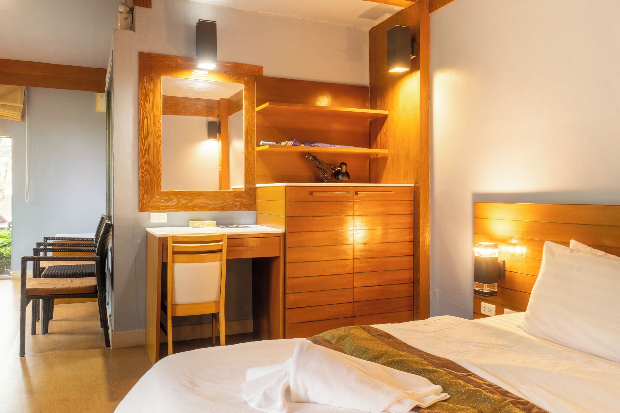 Une chambre d’hôtel équipée d’un lit, d’un bureau, d’une chaise et d’un miroir.