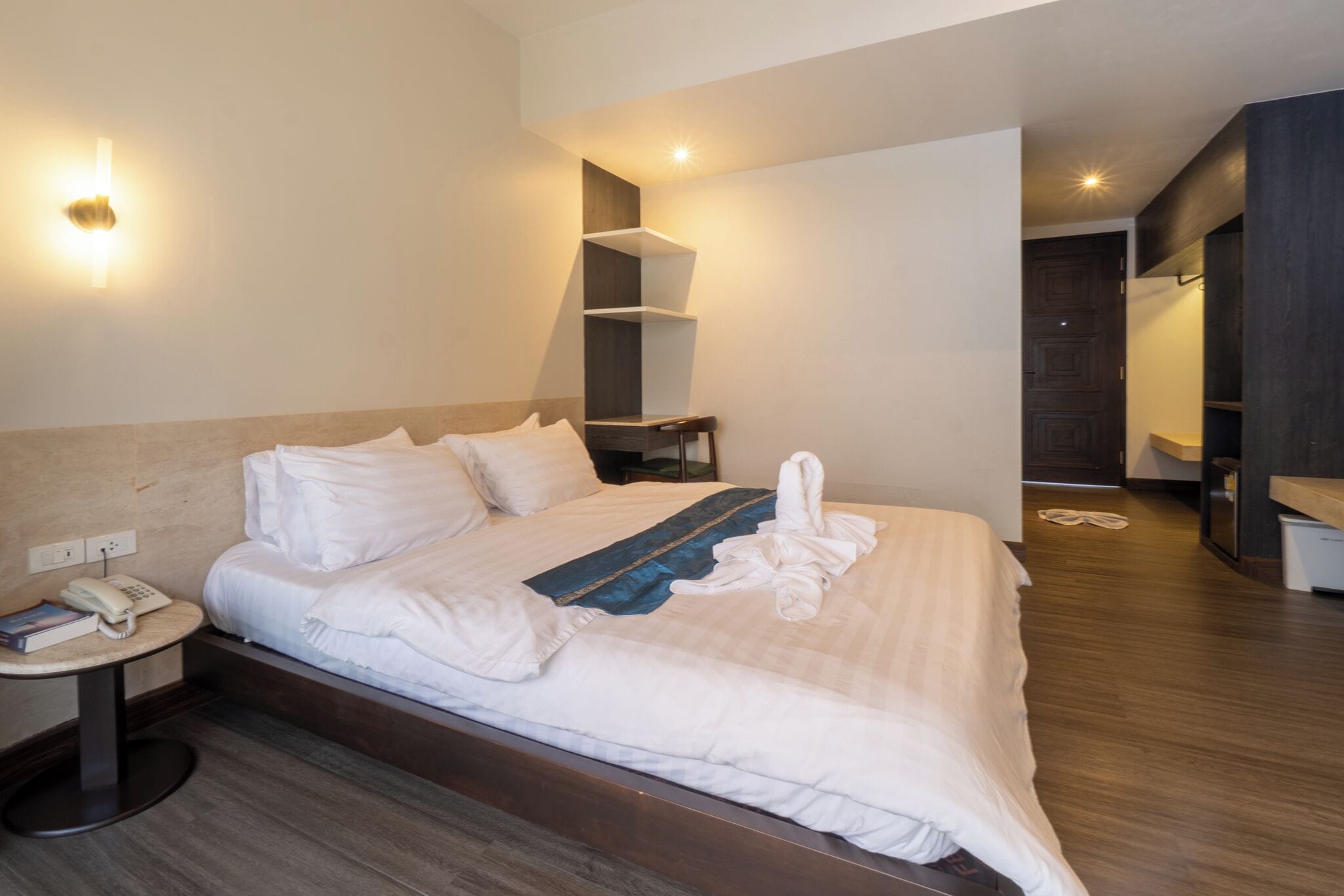 Ein Hotelzimmer mit Bett, Nachttisch und einer Wandleuchte.