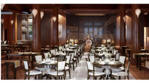 A spacious dining area with multiple tables and chairs, wooden columns, and hanging light fixtures.
