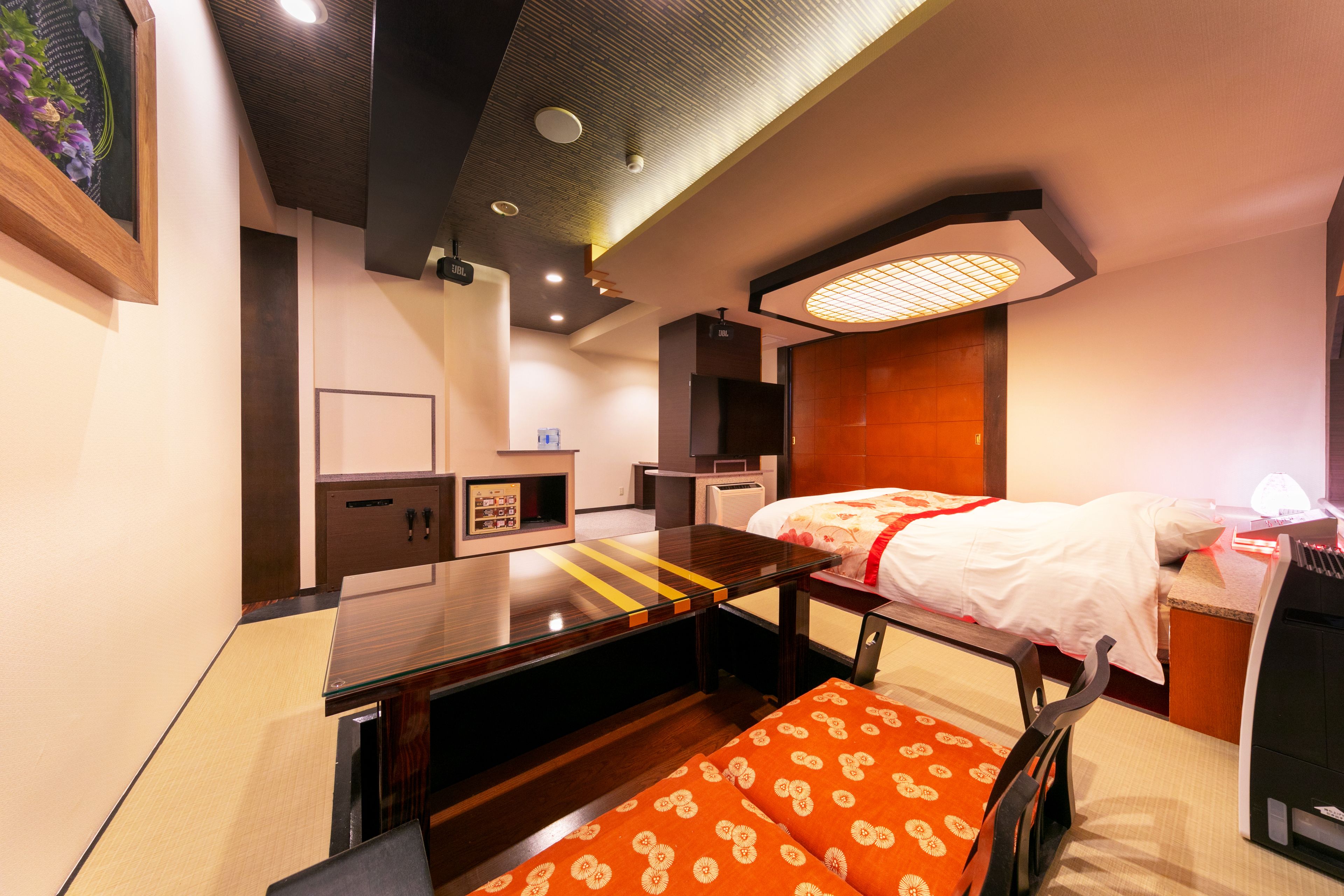 A modern hotel room with a bed, a desk, a chair, and a small table.