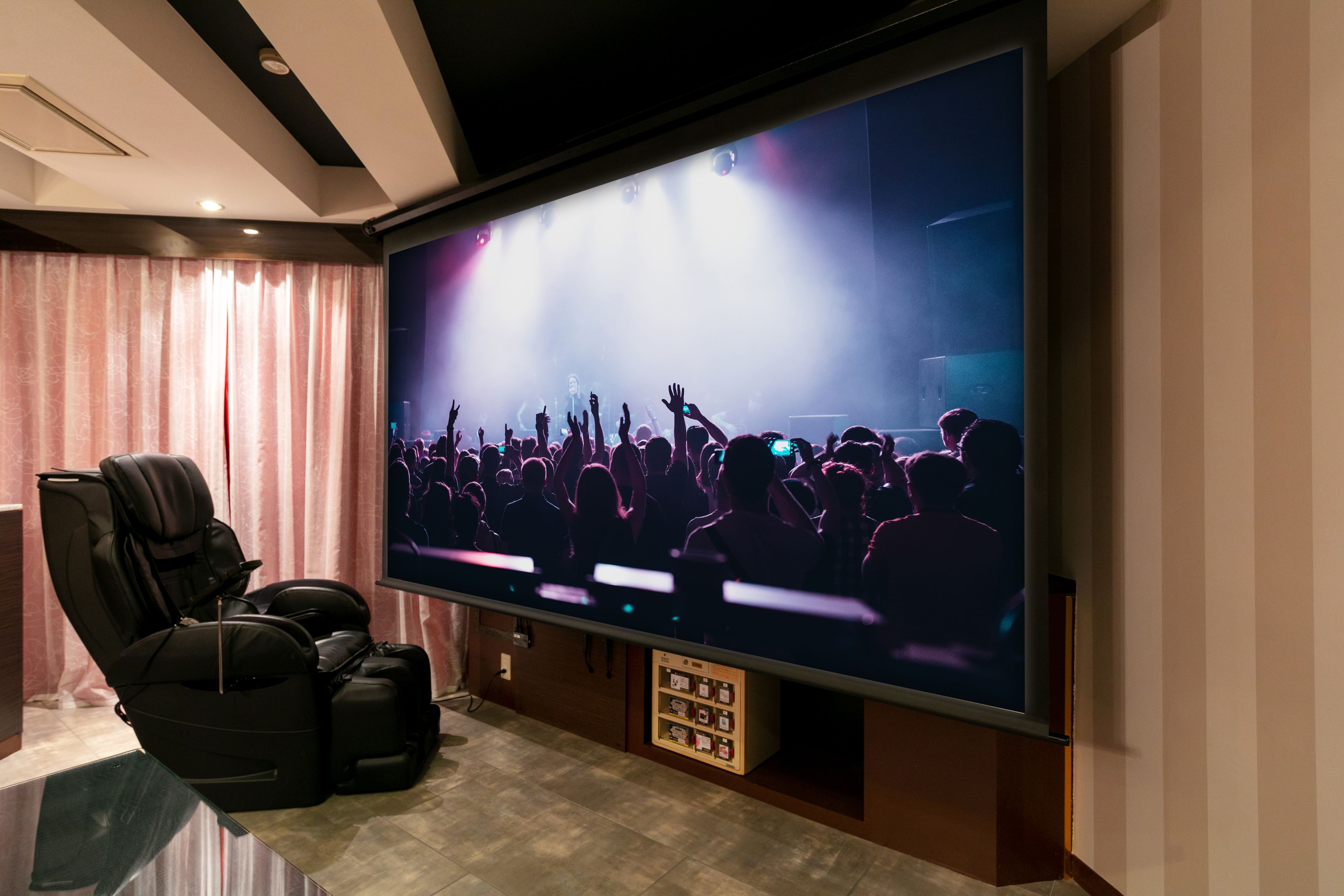 A home theater with a large flat-screen TV, reclining chairs, and a carpeted floor.