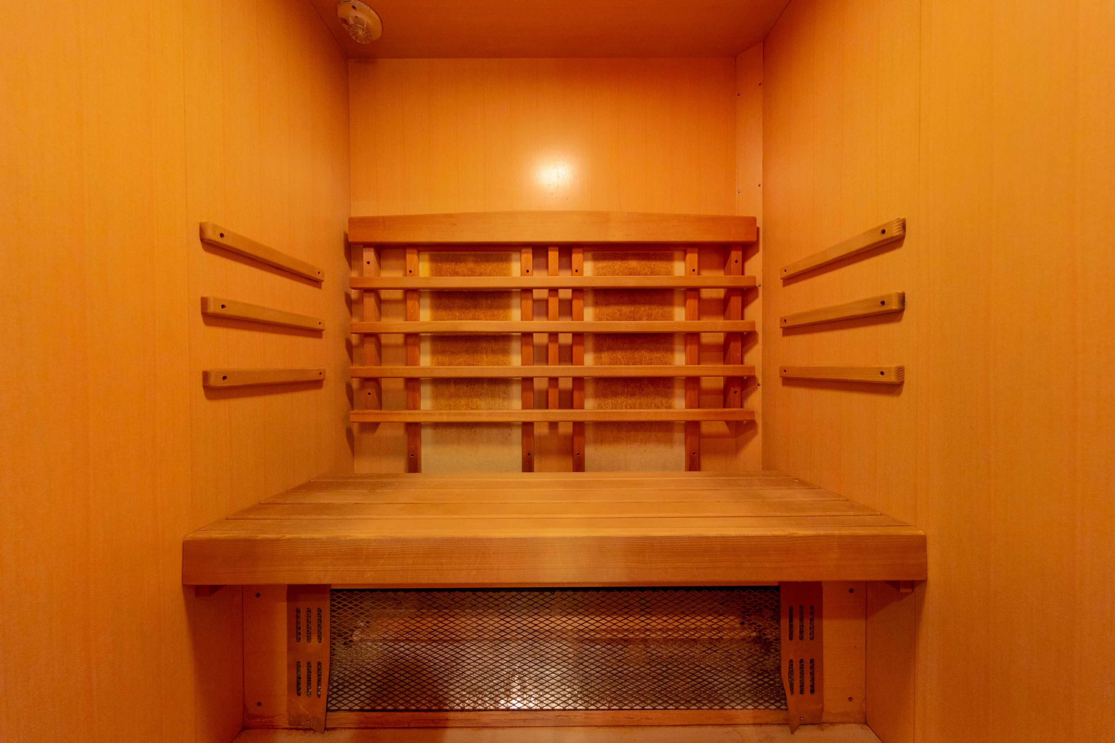 Eine Sauna mit Holzbänken und Ablageflächen für Handtücher.