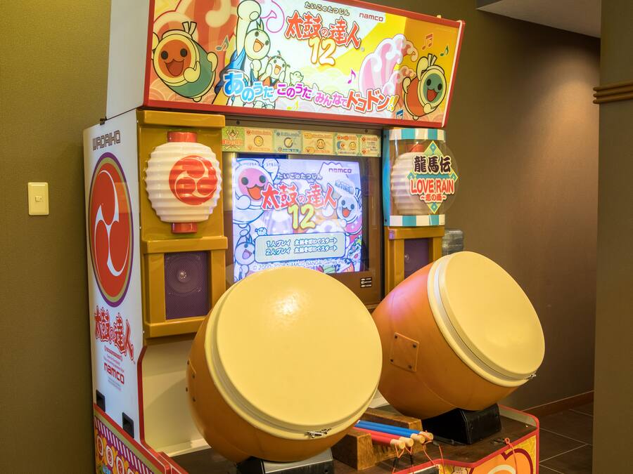 A game machine with two large drums and a screen displaying game instructions.