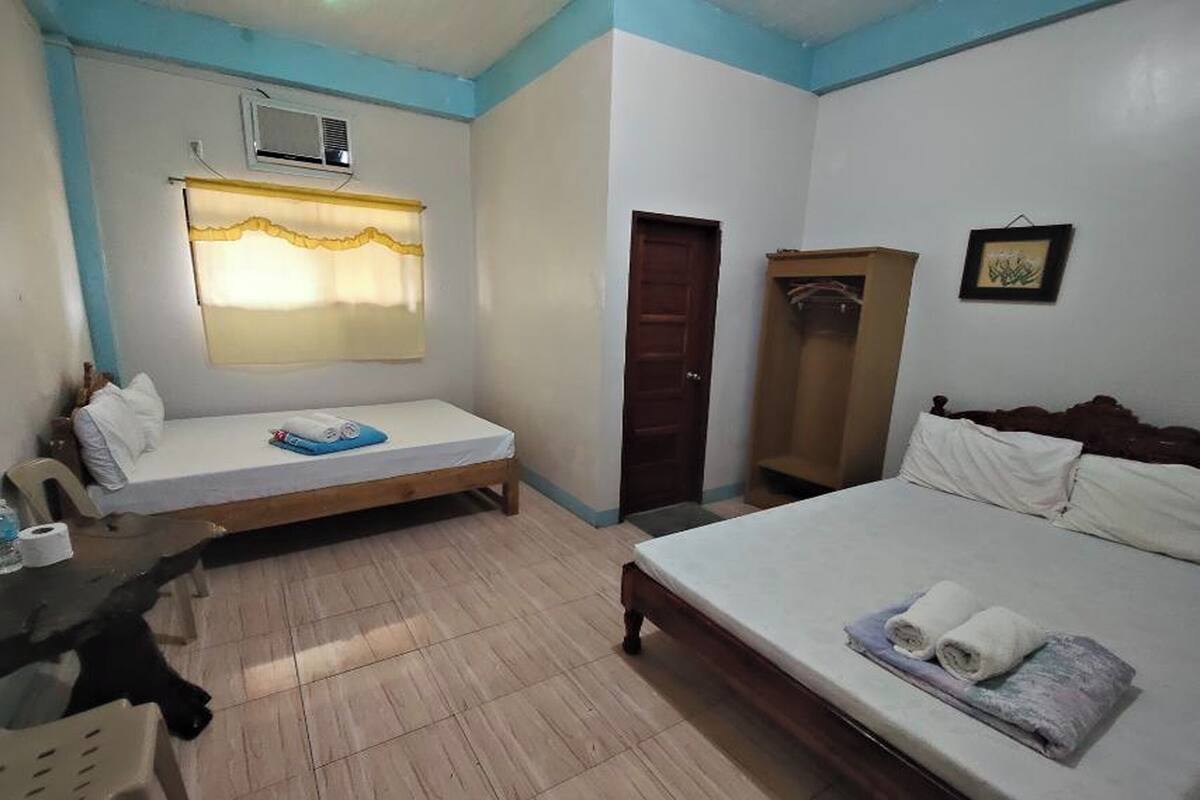 A room with a bed, a sofa, a wardrobe, and a desk.