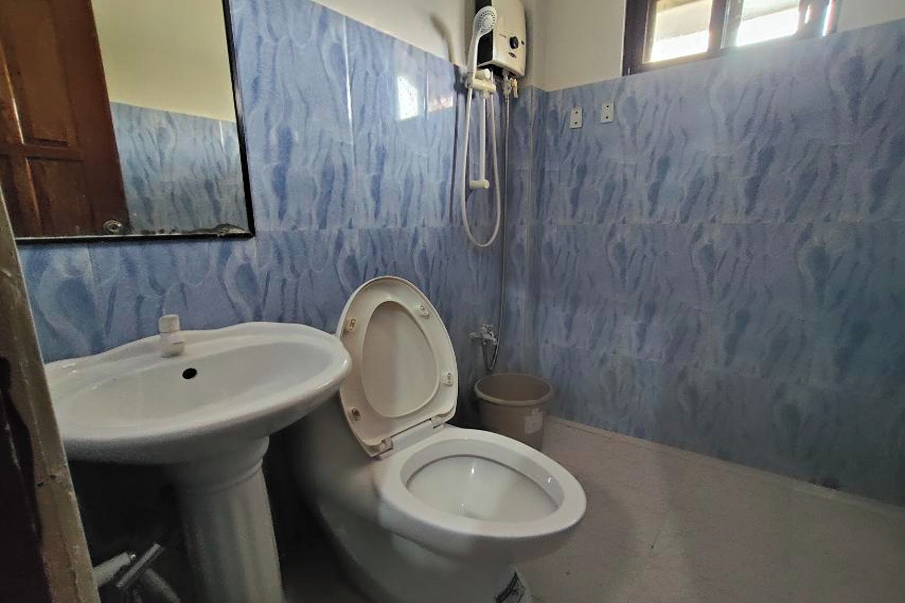 Un baño con inodoro, lavamanos y ducha.