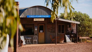 A rustic building labeled "Cheela Plains Station" with a reception desk, office, and outdoor seating area. - Cheela Plains Station (Nanutarra)