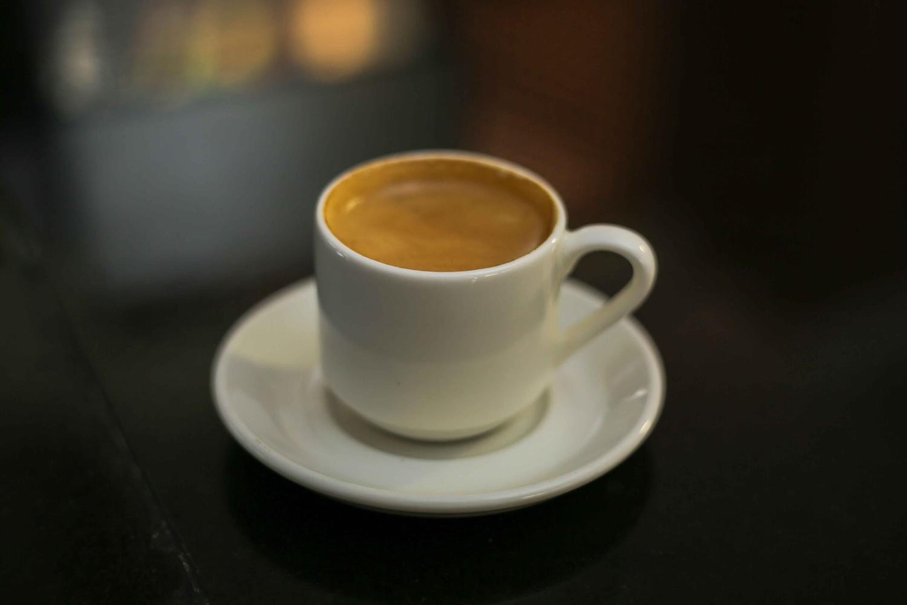 A white cup of coffee on a saucer.