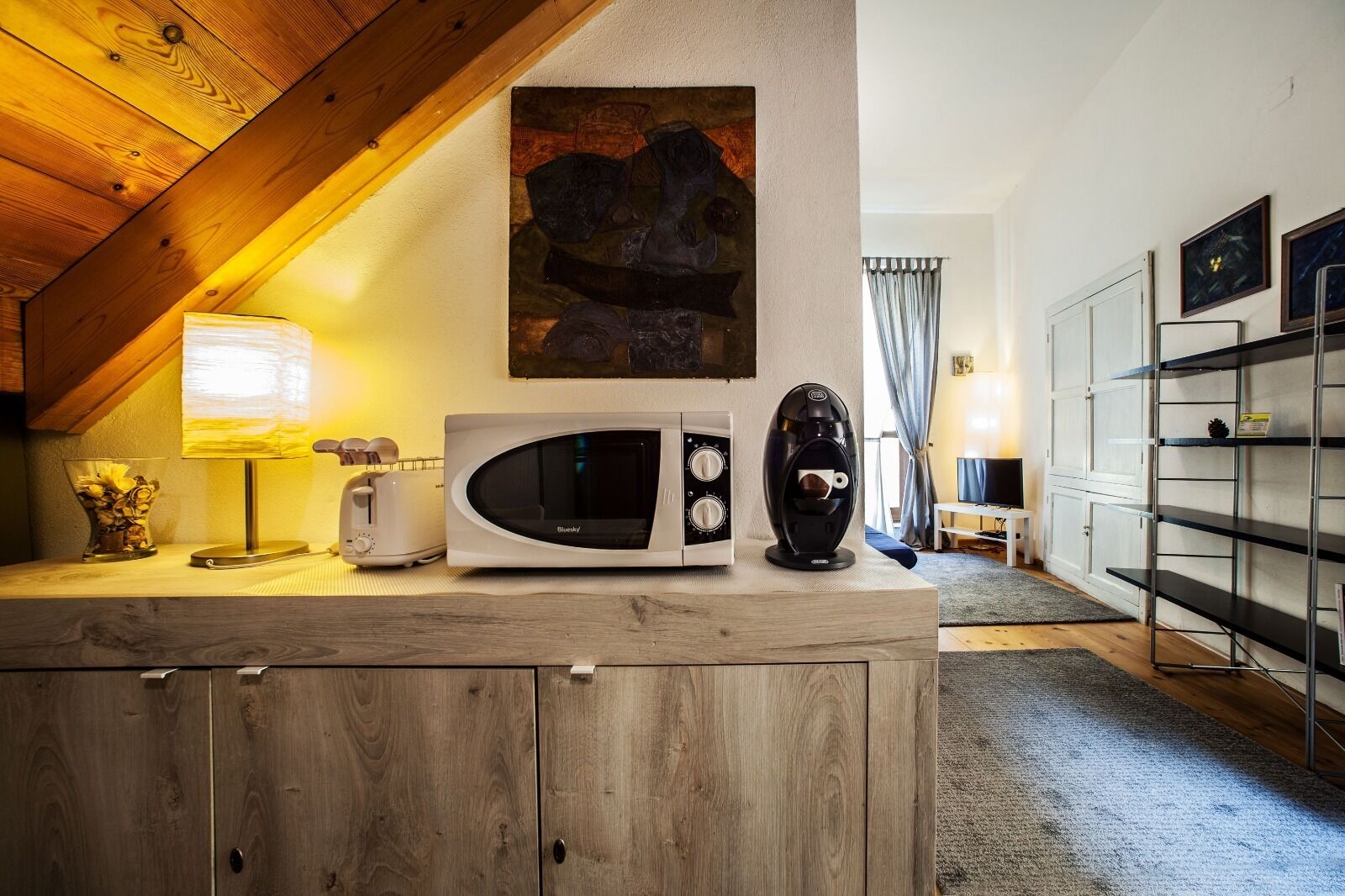 Eine Küche mit Mikrowelle, Toaster und Kaffeemaschine auf einer Holzausziehtischplatte.