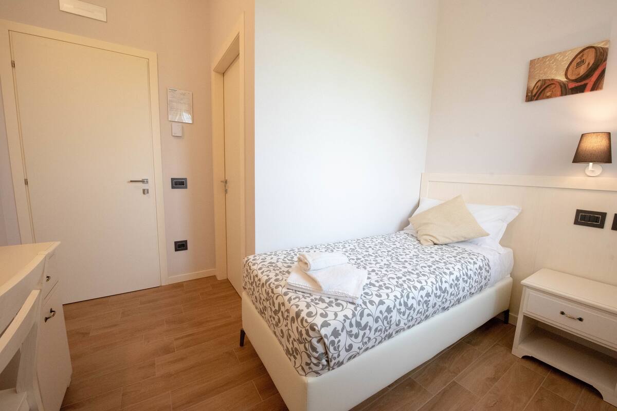 Une chambre à coucher avec un lit, une table de chevet et une commode.