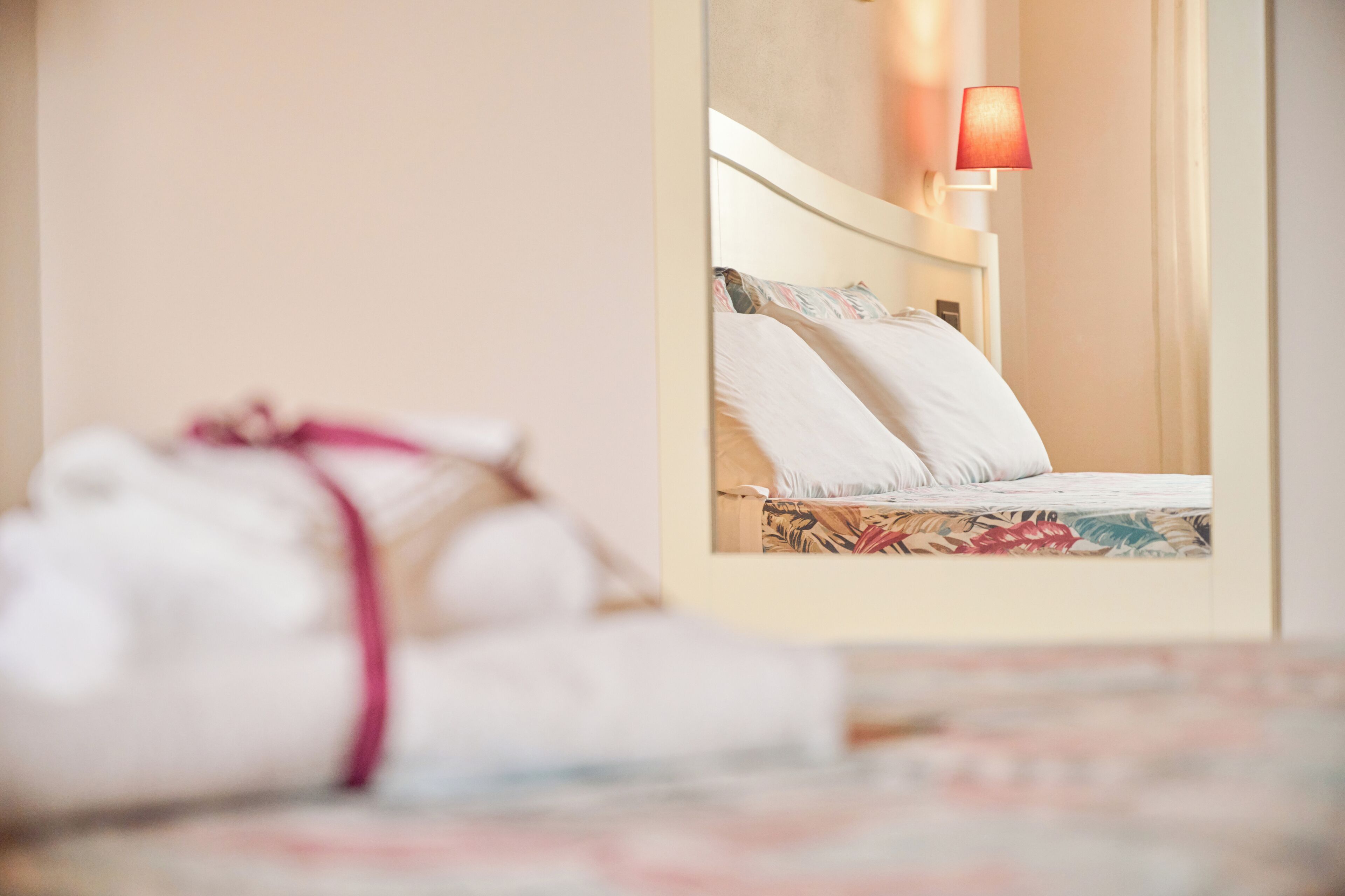 Una habitación de hotel con una cama bien hecha, una lámpara de noche y un baño visible.