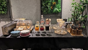 A buffet setup with a toaster, plates, condiments, and a coffee machine. - HOTEL SUI AKASAKA byABEST (Tokyo)