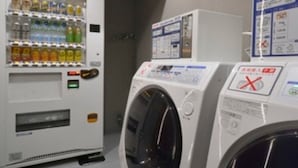 A laundry area with a vending machine and two washing machines. - HOTEL SUI AKASAKA byABEST (Tokyo)