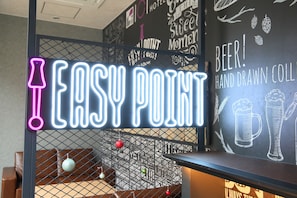 A neon sign reading "EASY POINT" in a room with a chalkboard wall featuring beer illustrations and text. - HOTEL SUI AKASAKA byABEST (Tokyo)