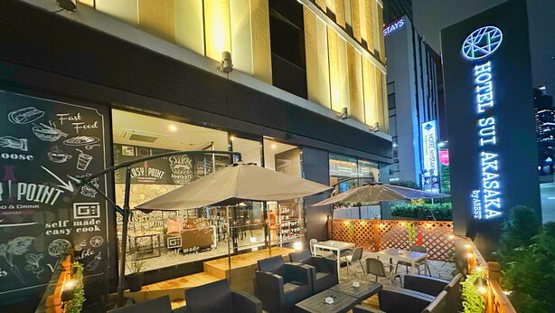 Un área de comedor en la azotea con asientos al aire libre y vistas de la ciudad.