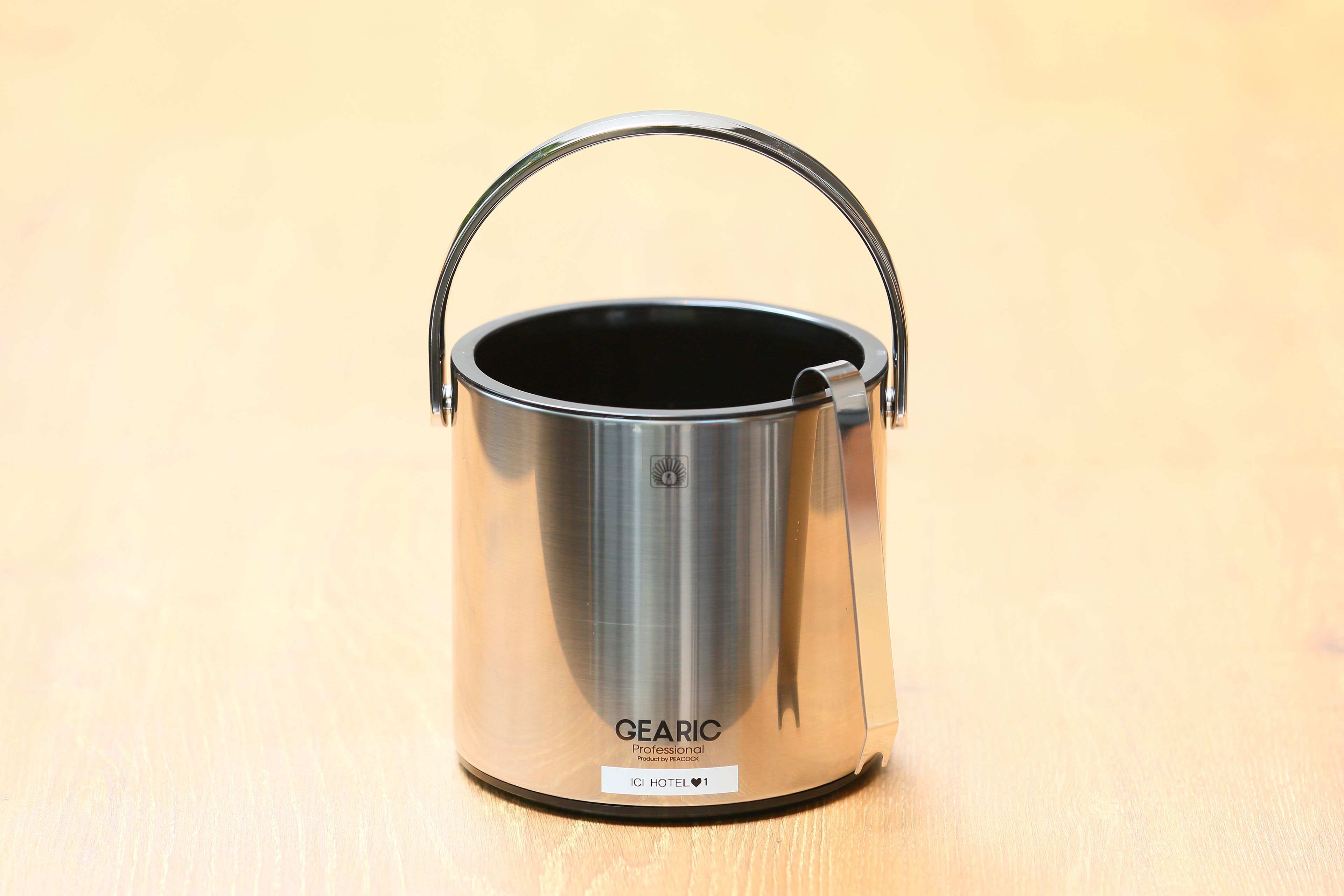 A stainless steel GEARIC pot with a handle on a wooden surface.