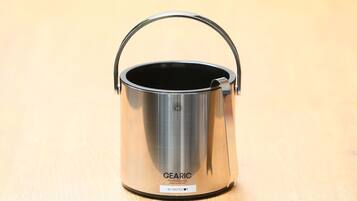 A stainless steel GEARIC pot with a handle on a wooden surface.