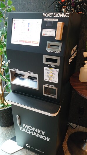 A money exchange machine with multiple service options including bill insertion, receipt outlet, and coin outlet. - HOTEL SUI AKASAKA byABEST (Tokyo)