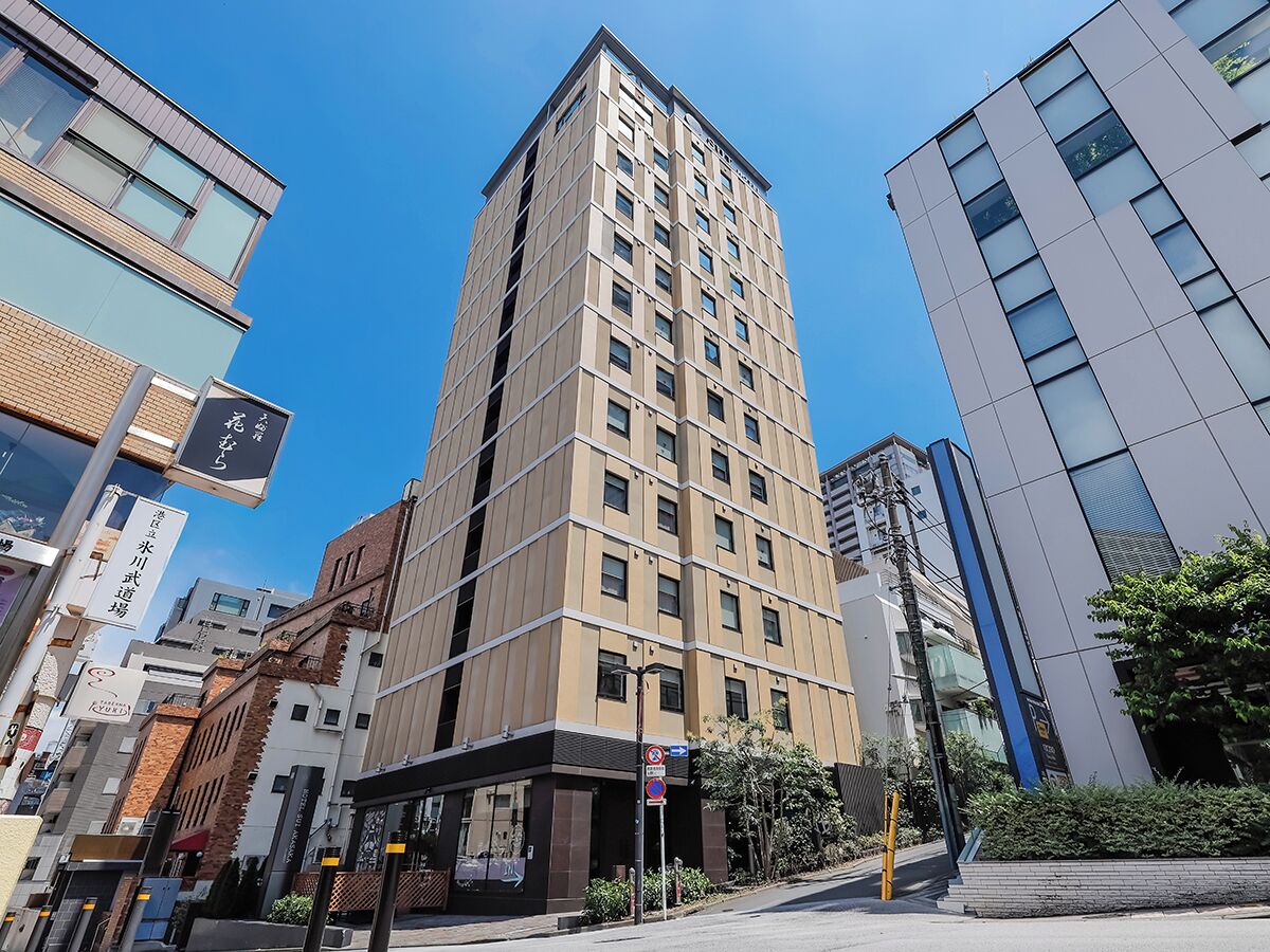 A multi-story building with a modern architectural design, featuring a prominent vertical line pattern on the facade.