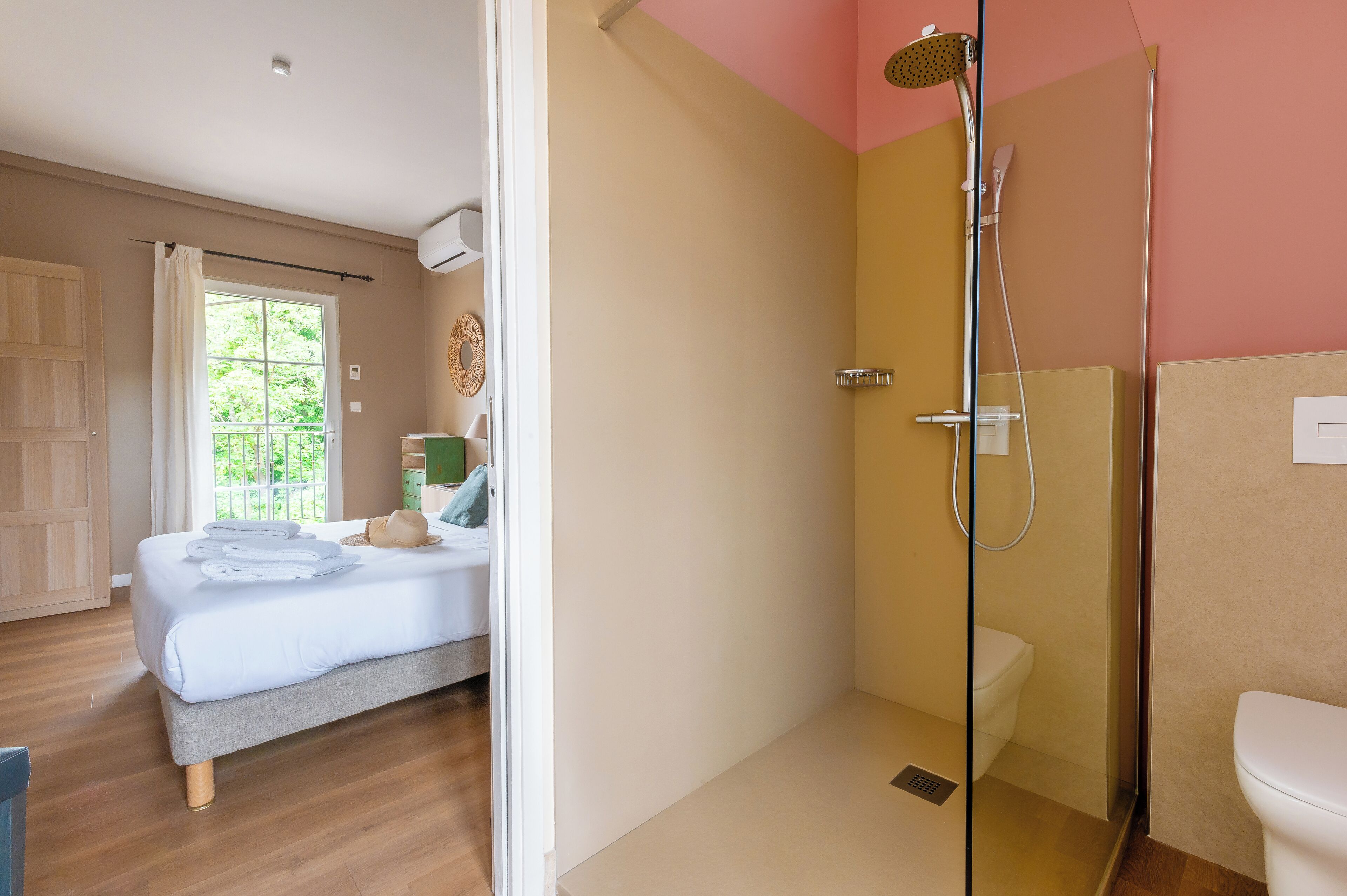 Une chambre avec un lit, une salle de bain avec une douche et des toilettes.