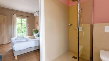Une chambre avec un lit, une salle de bain avec une douche et des toilettes.