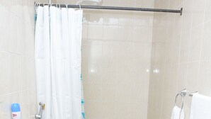 A bathroom with a toilet, shower curtain, and a towel rack. - Cozy and Furnished 1 Bedroom Apartment (Nairobi)