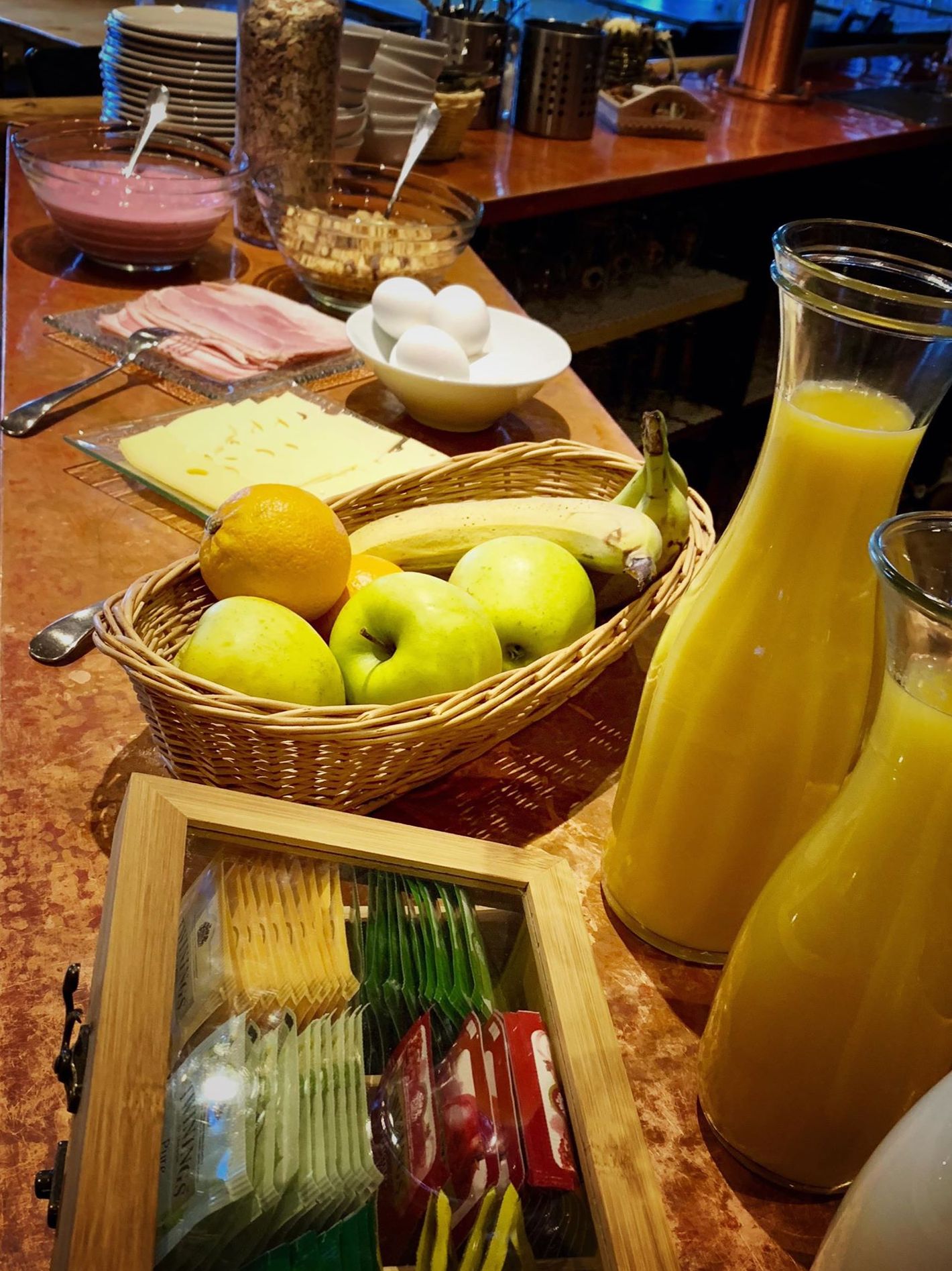 A breakfast buffet with various food items and a juice dispenser.