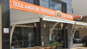 Una fachada con un letrero que dice "BOULANGERIE PATTISSERIE" y "THE HARLEM CAFE BISTRO".
