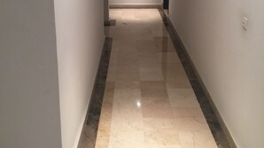 Un pasillo con paredes blancas y suelo de mármol.