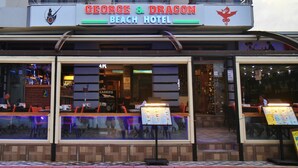 The exterior of George & Dragon Beach Hotel with a bar area visible through the windows. - George Dragon Beach Hotel (Marmaris)
