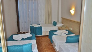 A hotel room with two single beds, a wooden headboard, a bedside table with a lamp, and a window with sheer curtains. - George Dragon Beach Hotel (Marmaris)