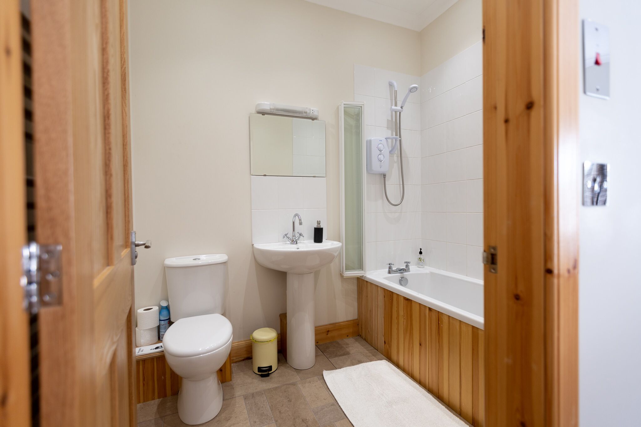 A bathroom with a toilet, sink, and shower.