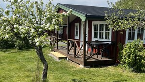 A red wooden house with a porch and a grassy yard. - Mälarhusen Semesterby Österlen - Stugor & Gårdssviter (Loderup)