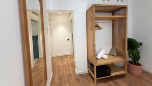 Una habitación con un armario de madera, una planta en maceta y un microondas.