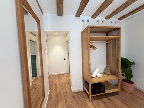 A room with a wooden wardrobe, a potted plant, and a microwave. - Casa Vaganto (Barcelona)