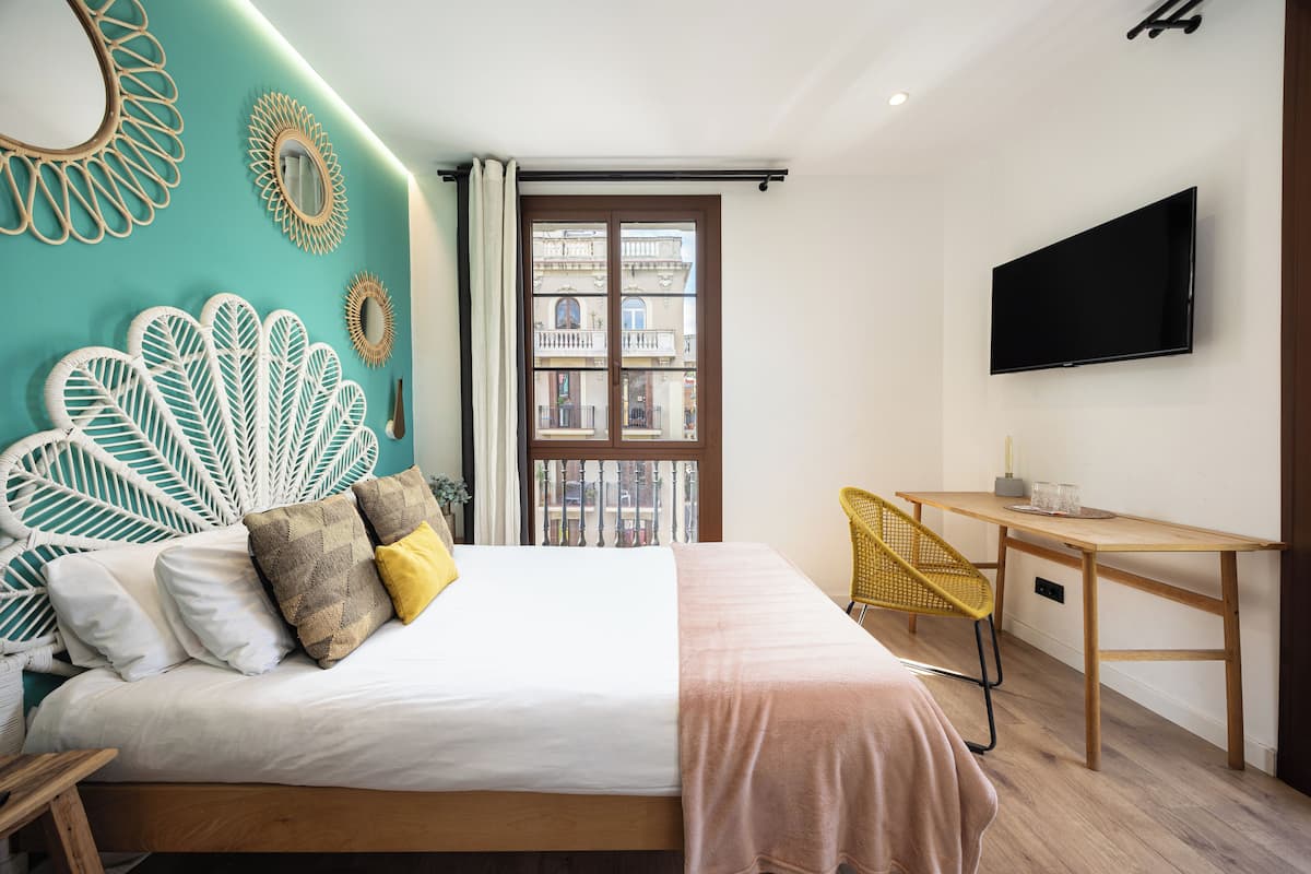 Ein modernes Hotelzimmer mit Bett, Schreibtisch und Fernseher.