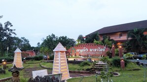 A resort with a large sign, a well-maintained garden, and a building with a tiled roof. - Khao Saming Paradise Resort (Khao Saming)