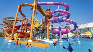 Parque acuático con múltiples toboganes y una piscina.