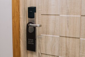 A door with a "Please Do Not Disturb" sign and a modern electronic lock. - Hotel Kamarkyi (Yangon)