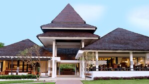 Een resort met een centraal paviljoen en twee gebouwen met rieten daken.