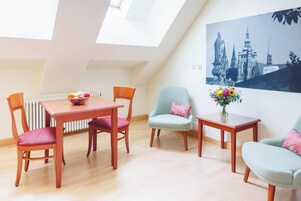 Uma sala de estar moderna com área de jantar, apresentando uma mesa, cadeiras, um radiador e uma janela grande com claraboia.