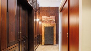 A hallway with wooden paneling, a marble fireplace, and a wooden door. - Hapimag Resort Prague (Prague)