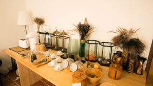 Una mesa de madera con varios utensilios de cocina, incluyendo frascos de vidrio, una cafetera y un hervidor de agua.