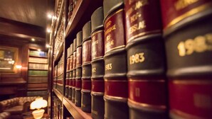 Una hilera de libros de leyes en una estantería, en una biblioteca o sala de estudio.