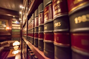 Diversos livros de direito dispostos numa estante em uma biblioteca ou sala de estudo.