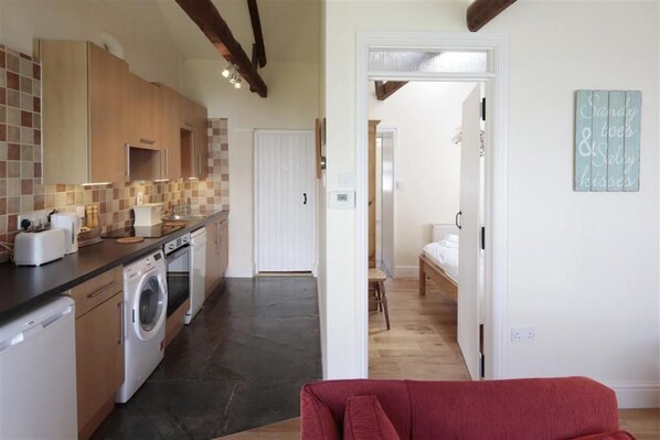 A compact kitchen with modern appliances and a small dining area.