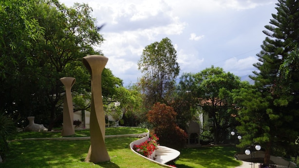 Ein angelegter Garten mit Skulpturen und verschiedenen Bäumen.