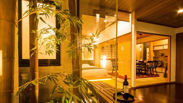 Une chambre d’hôtel moderne équipée d’un lit, d’un coin repas et offrant une vue sur l’extérieur.
