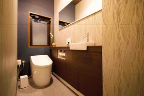 Un baño pequeño con inodoro, lavabo y espejo.